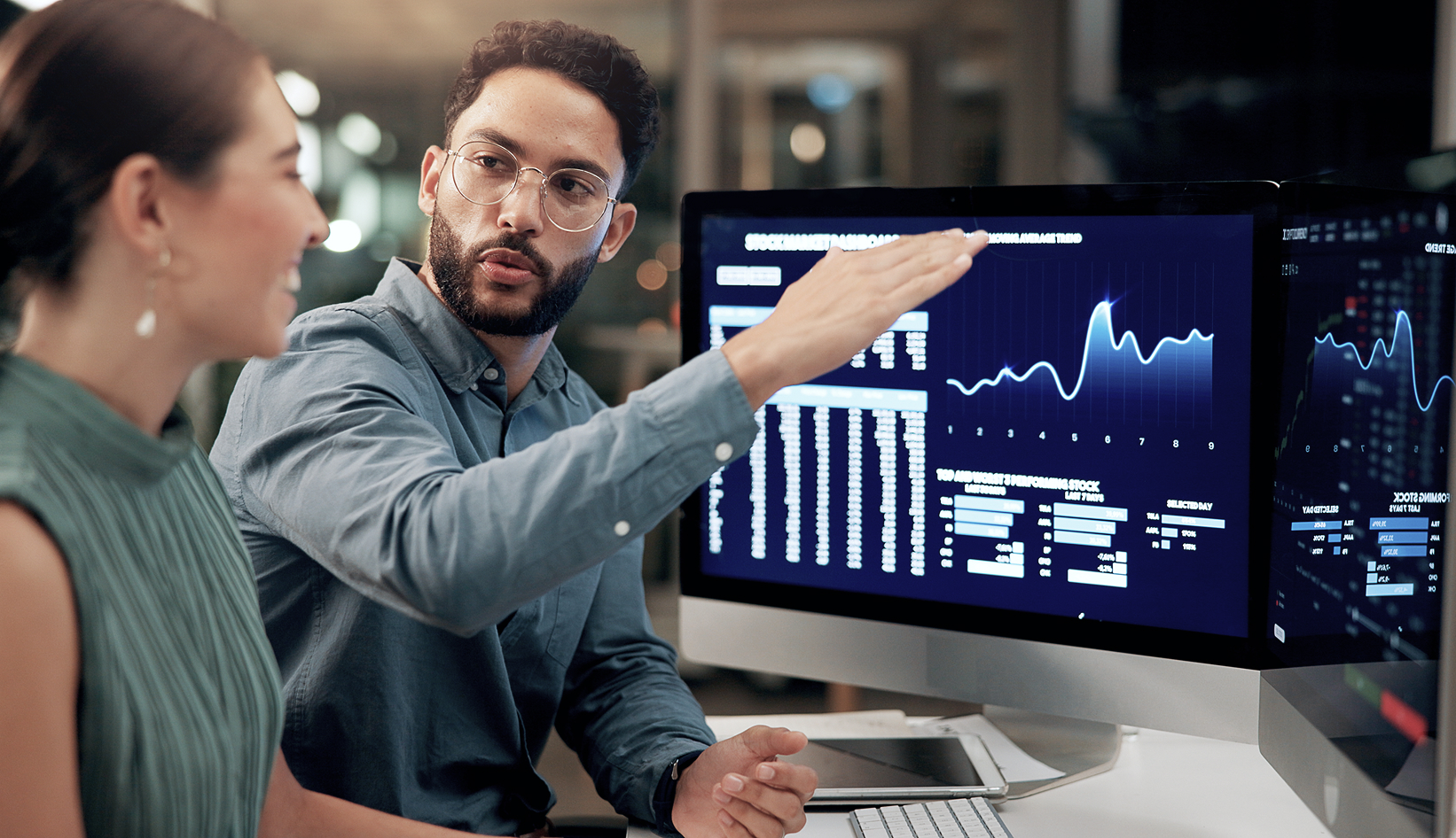 Two employees looking at profits going up